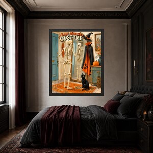 May include: A framed wall art print titled LAST MINUTE COSTUME featuring a skeleton standing before a mirror, wearing a black and orange cape with a witch hat. A black cat sits on an orange rug near a blue door, a pumpkin, and a wooden cabinet.