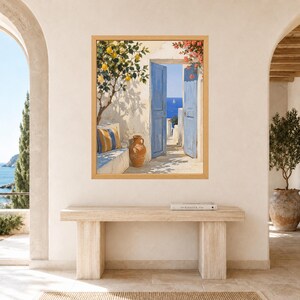 May include: A framed wall art print depicting a Mediterranean scene with an open blue door, a lemon tree, a terracotta vase, and a striped cushion on a stone bench. The view through the doorway shows a bright blue sea and a distant sailboat.