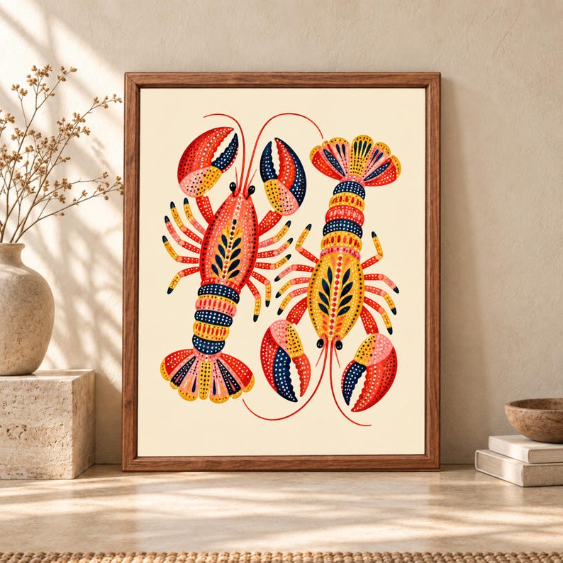 Framed colorful lobster wall art featuring two decorative red, yellow, navy and coral lobsters with dotted folk-art patterns on a warm cream background.