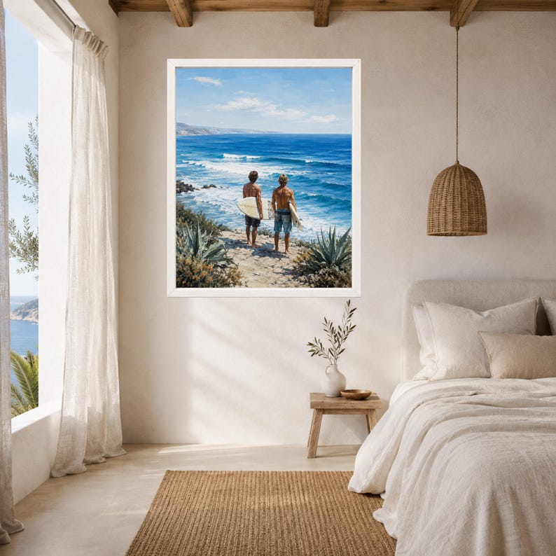 Puede incluir: Una impresi&oacute;n de arte mural enmarcada que representa a dos personas de pie en un acantilado arenoso con vistas a un oc&eacute;ano azul con olas. Cada persona sostiene una tabla de surf blanca. La escena incluye plantas costeras verdes.