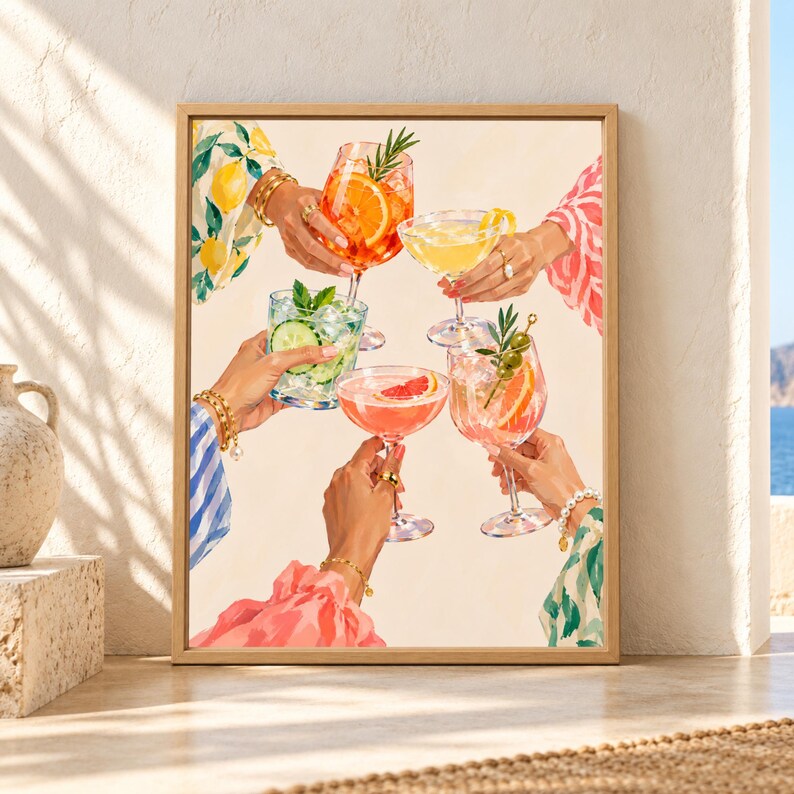 Framed colorful cocktail cheers wall art showing five hands raising citrus, spritz, cucumber and herb-garnished drinks with bright patterned sleeves and jewelry against a warm cream background.