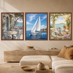 Puede incluir: Un conjunto de tres cuadros enmarcados con escenas costeras. La imagen de la izquierda muestra un patio con sillas y una mesa frente al mar. La imagen central representa un velero blanco en el agua. La imagen de la derecha muestra una mesa.
