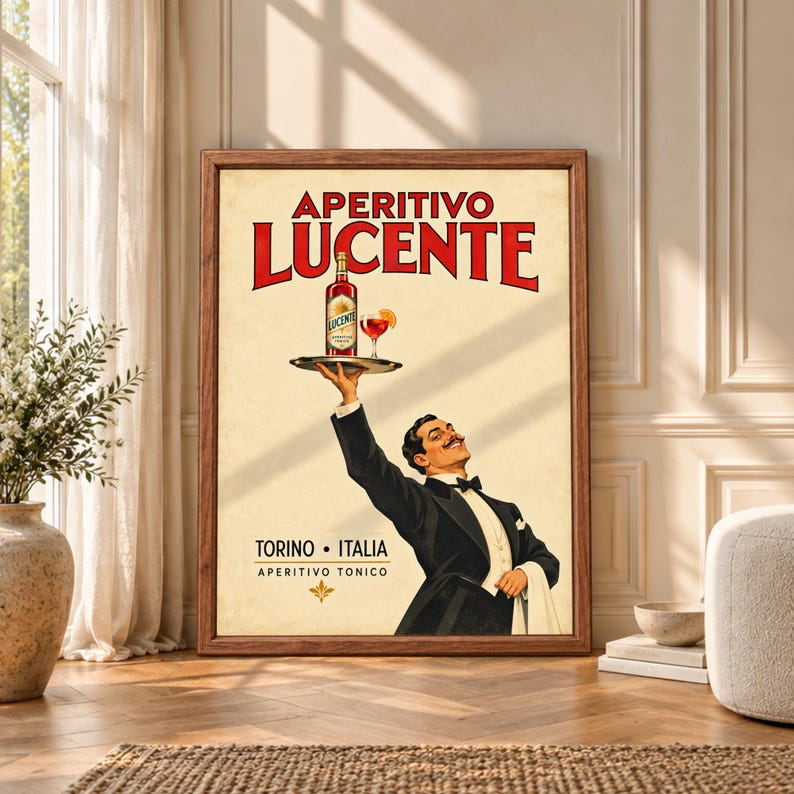 Framed vintage Italian aperitivo wall art showing a smiling tuxedoed waiter raising a tray with a bottle and red cocktail beneath bold Aperitivo Lucente and Torino Italia typography.