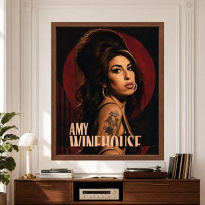 Framed Amy Winehouse wall art featuring a vintage-inspired retro soul portrait with signature beehive hair, winged eyeliner and tattoos against a burgundy circle and black background with bold Amy Winehouse typography above a record player console.