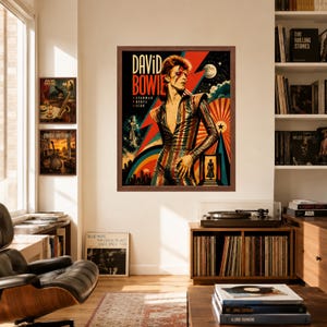 May include: A framed wall poster featuring a stylized illustration of David Bowie in a striped jumpsuit, with the text DAVID BOWIE, STARMAN, REBEL, ICON. The artwork includes a red lightning bolt, a moon, and a sunburst design in vibrant colors.