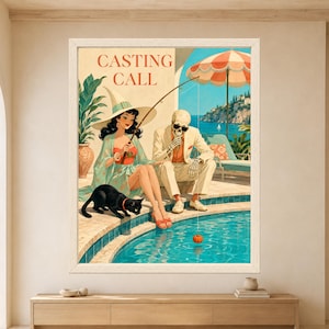 Framed Casting Call skeleton wall art featuring a stylish witch fishing with a tiny pumpkin beside a skeleton and black cat at a colorful retro swimming pool overlooking the coast.