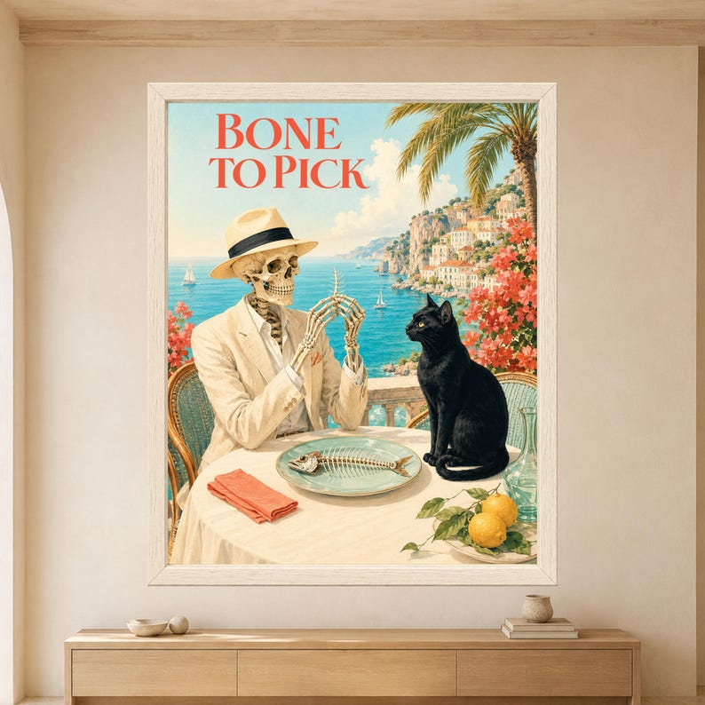 Framed Bone to Pick wall art showing a skeleton in a cream suit holding a fish bone across from a black cat beside a fish skeleton on a sunny Mediterranean seaside terrace.