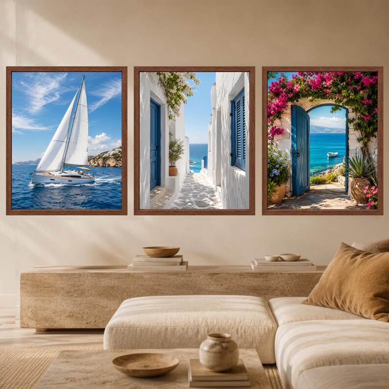 K&ouml;nnte beinhalten: Ein Set aus drei gerahmten Wandbildern mit mediterranen K&uuml;stenmotiven. Das linke Bild zeigt ein Segelboot auf blauem Wasser, das mittlere eine wei&szlig;e Gasse mit blauen T&uuml;ren und das rechte eine blaue T&uuml;r, die von rosa Blumen umrahmt wird.