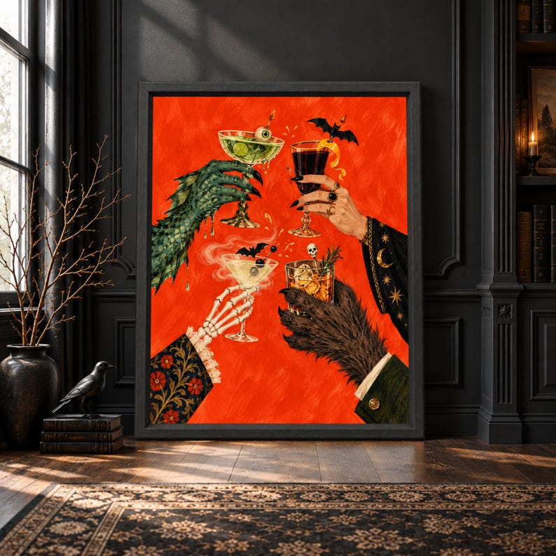 Framed Halloween cocktail wall art showing a skeleton hand, witch hand and monster claws raising spooky drinks with bats, an eyeball and skull garnishes against a bright orange background.