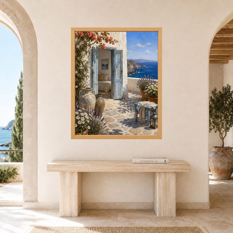 K&ouml;nnte beinhalten: Ein gerahmter Wandkunstdruck, der eine mediterrane K&uuml;stenszene mit einer offenen blauen T&uuml;r, einer Steinterrasse, Terrakottat&ouml;pfen, bl&uuml;henden Blumen und einem Blick auf das tiefblaue Meer unter klarem Himmel in einem hellen Holzrahmen zeigt.