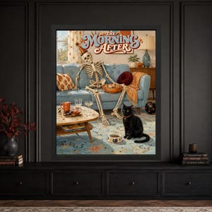Framed funny Halloween wall art showing a tired skeleton in a party hat slumped on a blue retro sofa beside a black cat, leftover snacks, glasses, confetti and The Morning After lettering.