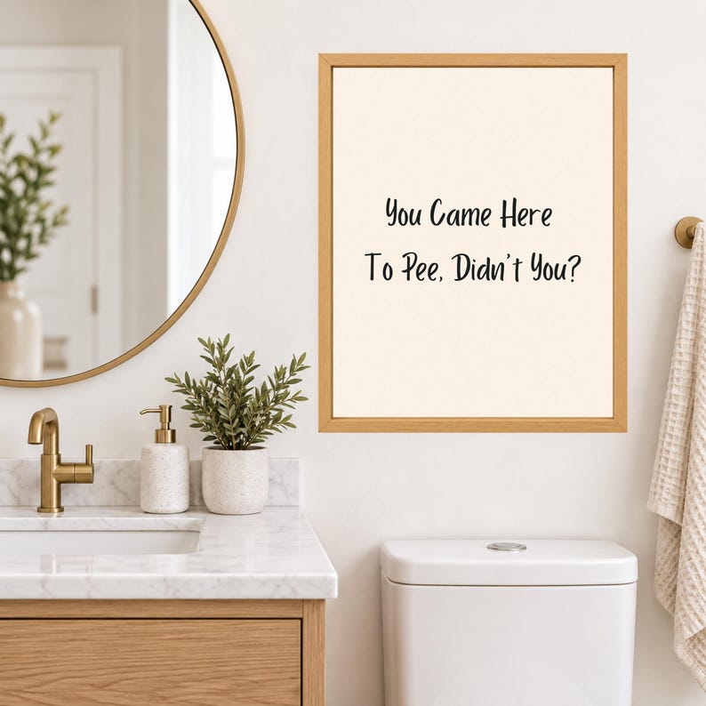 May include: A rectangular wall art print in a light wood frame featuring the black text "You Came Here To Pee, Didn't You?" on a cream-colored background. The print is displayed on a white wall above a white toilet in a bathroom setting.