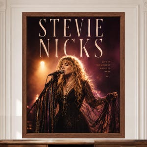 May include: A framed wall art print featuring Stevie Nicks performing on stage. The text reads STEVIE NICKS and LIVE IN THE MOMENT MAGIC IS REAL. The image shows a person with long blonde hair wearing a black lace dress, singing into a microphone.