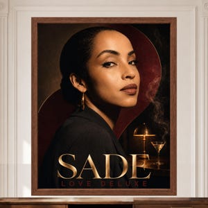 K&ouml;nnte beinhalten: Ein gerahmter Portr&auml;tdruck einer Frau mit dunklem Haar in einem schwarzen Blazer und goldenen Creolen. Der Text SADE LOVE DELUXE erscheint in goldener Schrift am unteren Rand. Eine kleine Lampe und ein Cocktailglas mit Rauch sind zu sehen.