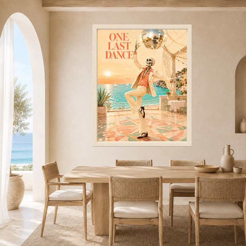 May include: A framed wall art print titled ONE LAST DANCE featuring a skeleton wearing a cream suit and orange shirt, dancing on a tiled terrace overlooking a blue sea at sunset with a disco ball hanging above in a warm, coastal setting.