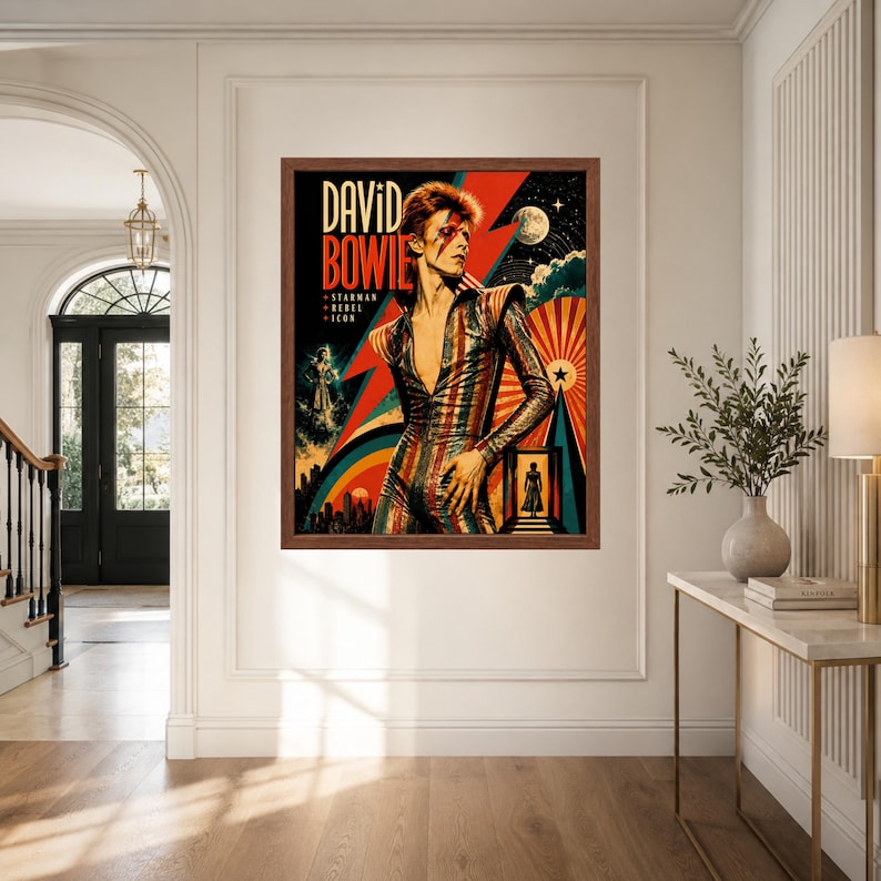 May include: A framed wall art print featuring a stylized portrait of David Bowie in a striped jumpsuit. The graphic includes a red lightning bolt, a moon, and the text "DAVID BOWIE STARMAN REBEL ICON" set against a dark background with colorful rays.