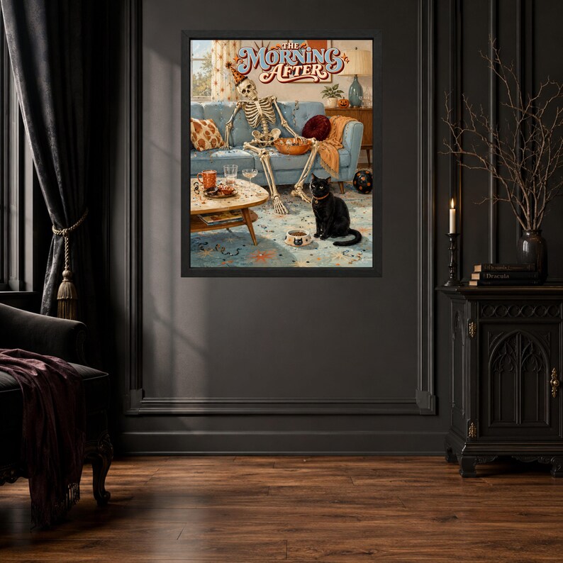May include: A framed wall art print titled The Morning After, featuring a skeleton wearing a party hat sitting on a blue sofa with a bowl of snacks, a coffee table with drinks, and a black cat sitting on the floor near a food bowl.