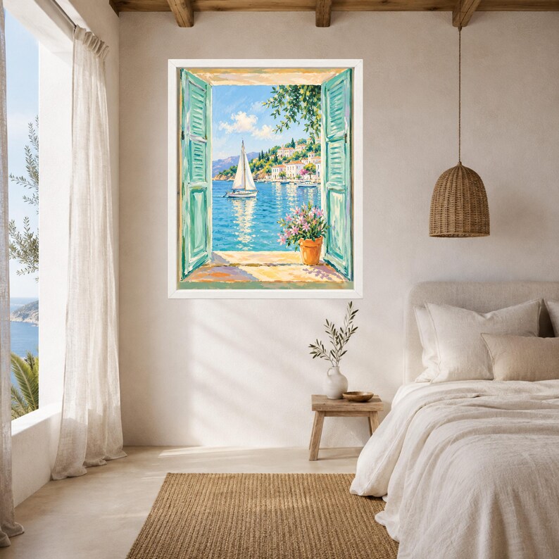 May include: A framed wall art print depicting an open window view of a coastal scene with a white sailboat on blue water, a hillside village with white buildings, and a terracotta pot with pink flowers on the windowsill, framed in white.