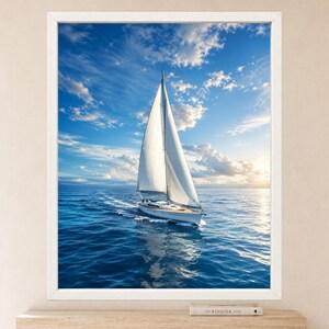 May include: A framed wall art print featuring a white sailboat with a tall mast and full sail gliding across deep blue ocean waters under a bright sky with scattered white clouds and a soft golden sun glow on the horizon at sunset.