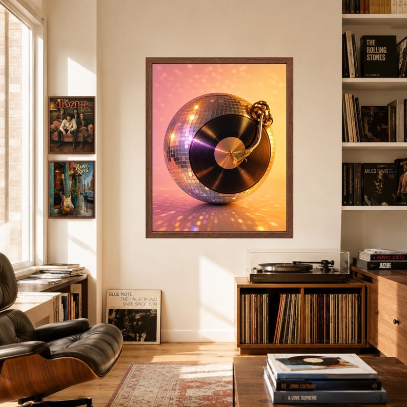 Puede incluir: Una impresi&oacute;n de arte mural enmarcada que presenta una bola de discoteca esf&eacute;rica integrada con un disco de vinilo negro y un brazo de tocadiscos en tono dorado. La composici&oacute;n se sit&uacute;a sobre un fondo c&aacute;lido y brillante con reflejos.