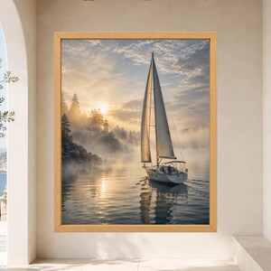 May include: A framed wall art print featuring a sailboat gliding across calm water during a golden sunrise. A lighthouse stands on a misty, tree-covered cliff in the background. The scene is illuminated by soft, warm light with clouds above.