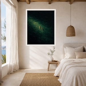 May include: A framed wall art print featuring an aerial view of two figures swimming in deep, dark green ocean water, illuminated by a single, bright shaft of sunlight that highlights the ripples and texture of the sea surface.