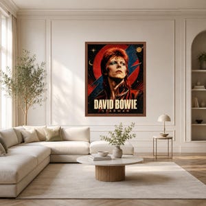 May include: A framed rectangular wall art print featuring a portrait of David Bowie with red hair and makeup. The background displays a large red circle, a blue lightning bolt, and celestial elements. The text DAVID BOWIE STARMAN is at the bottom.