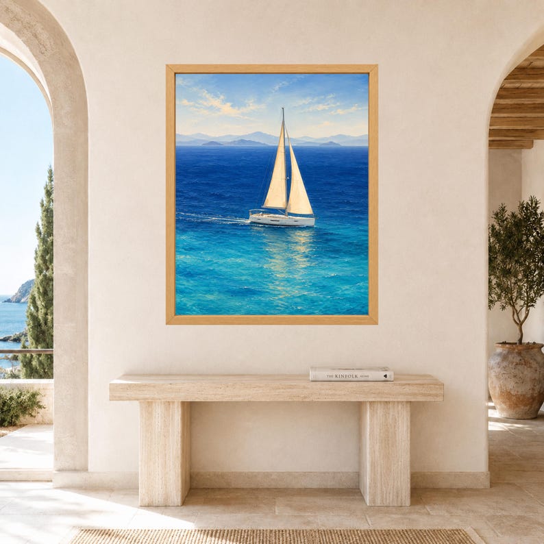Peut inclure: Une impression d'art encadr&eacute;e repr&eacute;sentant un voilier blanc aux voiles beiges naviguant sur des eaux oc&eacute;aniques bleu vif sous un ciel clair, avec des montagnes lointaines &agrave; l'horizon. L'&oelig;uvre est pr&eacute;sent&eacute;e dans un cadre en bois clair.