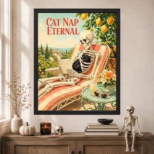 May include: A framed wall art print titled CAT NAP ETERNAL featuring a skeleton lounging on a red and white striped chair while reading a book with a black cat. A lemon tree, a small table with a drink, sunglasses, and flowers are visible.