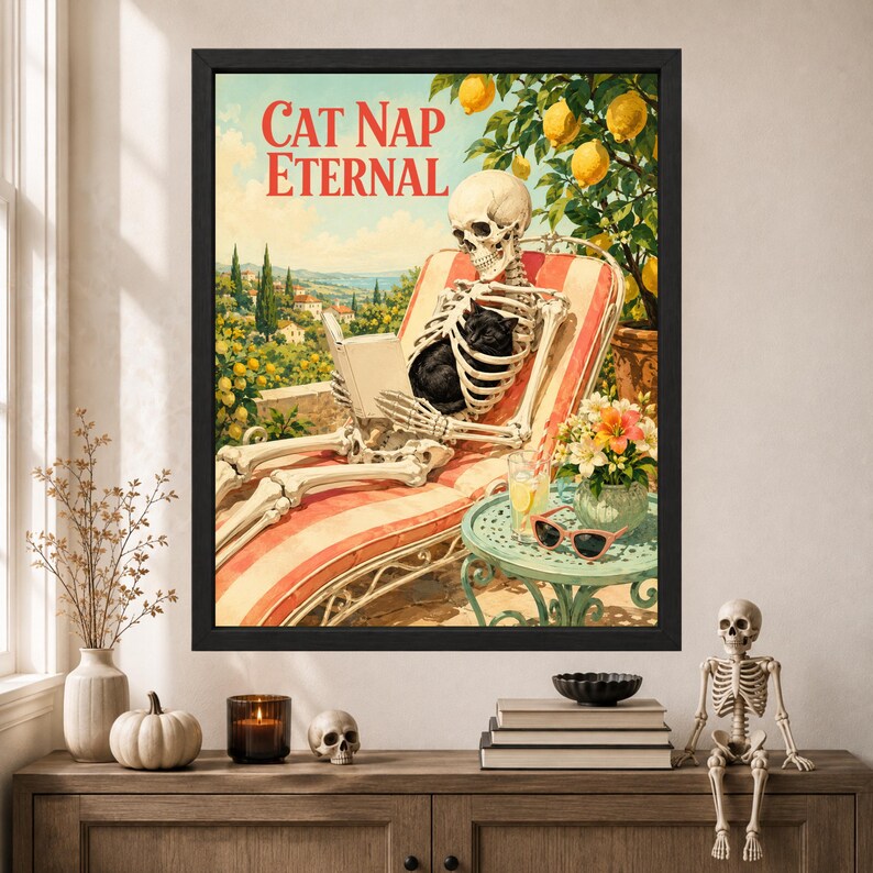 May include: A framed wall art print titled CAT NAP ETERNAL featuring a skeleton lounging on a red and white striped chair while reading a book with a black cat. A lemon tree, a small table with a drink, sunglasses, and flowers are visible.