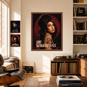 Puede incluir: Una l&aacute;mina art&iacute;stica enmarcada con un retrato de Amy Winehouse con su caracter&iacute;stico peinado de colmena, sobre un fondo circular rojo oscuro. El texto AMY WINEHOUSE est&aacute; impreso en blanco en la parte inferior del retrato dentro del marco.