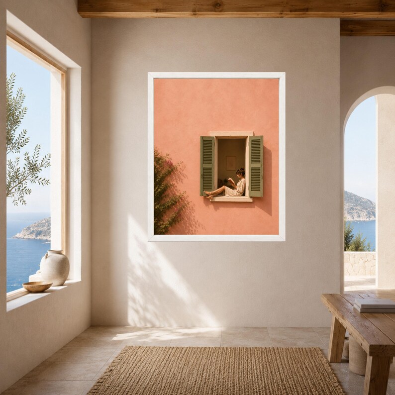 May include: A framed wall art print featuring a peach-colored building facade with an open window. Green shutters frame the window where a person sits reading. A leafy vine grows along the left side of the wall, casting a shadow on the surface.