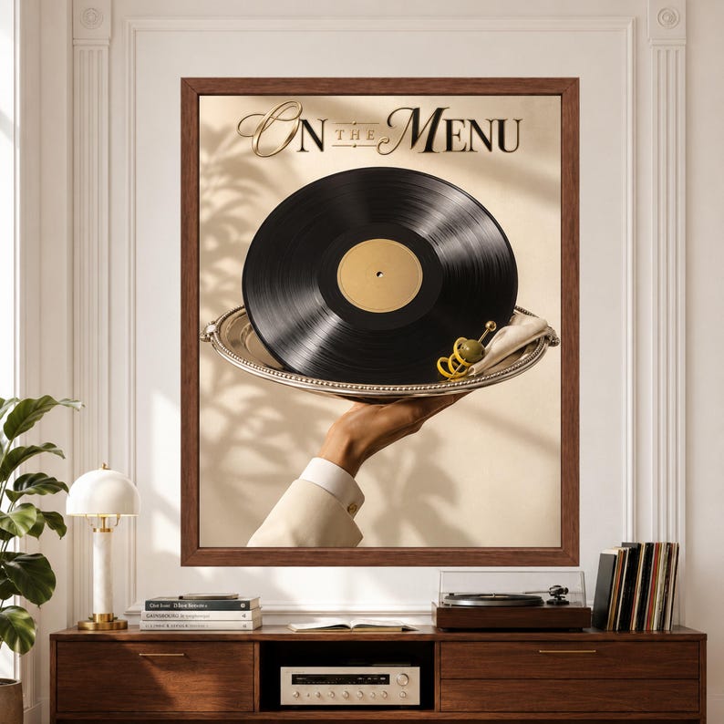 Framed vinyl record wall art featuring a glossy black record served on an elegant silver tray with olive and citrus garnish, held against a warm cream minimalist background beneath refined “On the Menu” typography above a record player console.