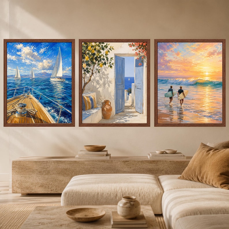 May include: A set of three framed wall art prints. The left print shows a sailboat on blue water from a deck. The center print depicts an open blue door with a lemon tree and a clay pot. The right print shows two surfers walking into the ocean.