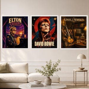 May include: Three framed wall art prints featuring musical themes. The left print shows Elton John at a piano, the center print depicts David Bowie with a red lightning bolt, and the right print displays a guitar, whiskey decanter, and the text Vinyl & Whiskey.