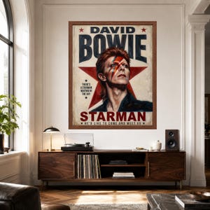 May include: A framed poster featuring a portrait of David Bowie with a red lightning bolt across the face, set against a large red star. The text reads DAVID BOWIE, STARMAN, and includes the lyrics THERE'S A STARMAN WAITING IN THE SKY.