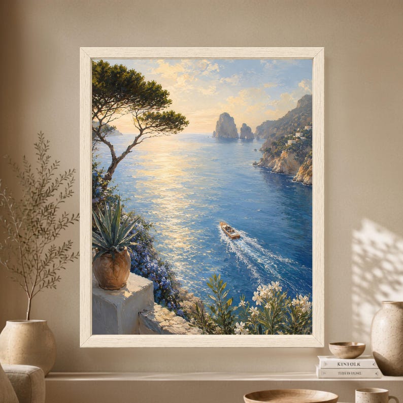Framed Capri wall art showing a small wooden boat crossing a blue Mediterranean sea beneath sunlit rocky cliffs and Faraglioni-style sea stacks, framed by pine, agave and coastal flowers.