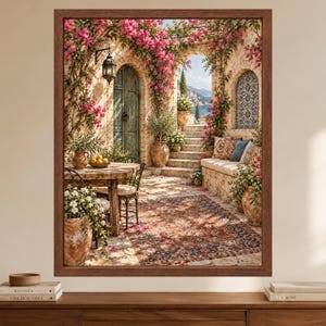 May include: A framed wall art print depicting a Mediterranean stone patio with a wooden table, chairs, and a patterned rug. The scene features stone arches, vibrant pink bougainvillea flowers, terracotta pots, and a view of distant hills.