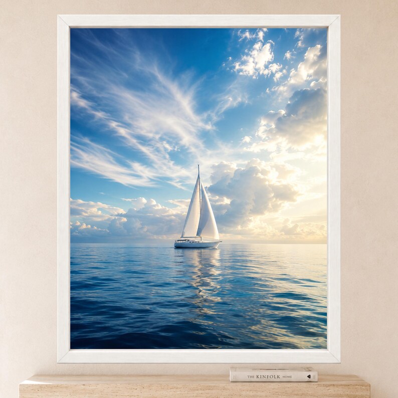 Pode incluir: Uma impress&atilde;o de arte de parede emoldurada apresentando um veleiro branco em &aacute;guas azuis calmas sob um c&eacute;u brilhante com nuvens finas e luz solar dourada. O veleiro est&aacute; centralizado, refletindo na &aacute;gua, dentro de uma moldura branca.