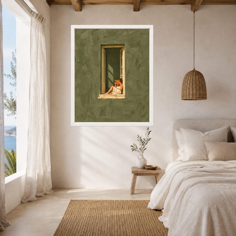 May include: A framed wall art print featuring a textured olive green wall with a central window. A figure sits in the window frame reading an orange book. The artwork is displayed in a white frame on a neutral-toned bedroom wall above a wooden side table.