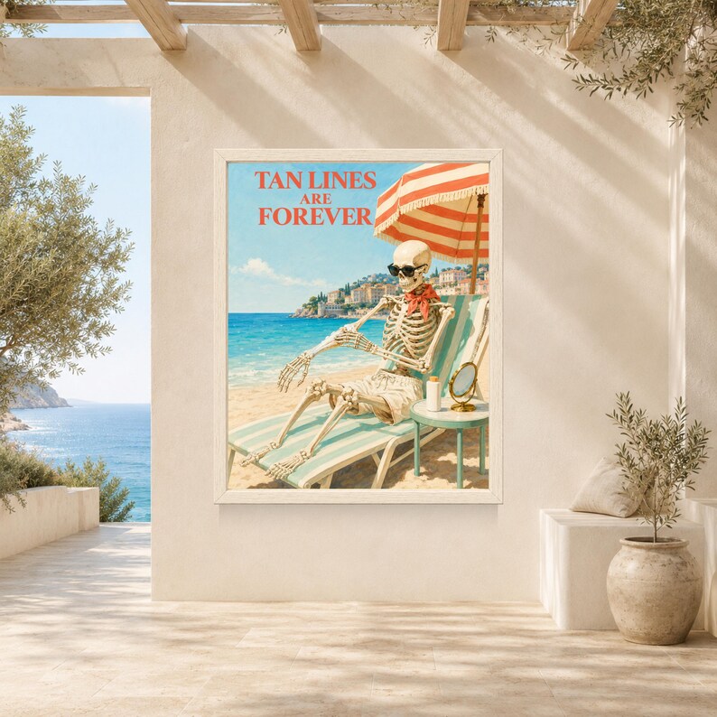 May include: A framed wall art print featuring a skeleton wearing sunglasses and a red neckerchief, lounging on a striped beach chair under a red and white umbrella. The text TAN LINES ARE FOREVER is printed in red above the skeleton on a beach.