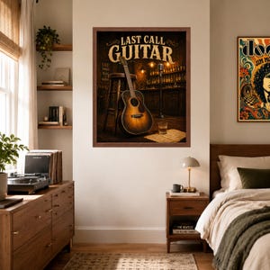 May include: A framed wall art print titled LAST CALL GUITAR featuring an acoustic guitar leaning against a wooden stool in a dimly lit bar setting with a microphone stand, a glass of amber liquid, and shelves of bottles in the background.