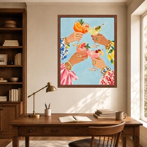 May include: A framed wall art print depicting four hands raised in a toast, each holding a different cocktail glass. The drinks are garnished with orange slices, cherries, and herbs. The hands are adorned with gold bracelets and rings.