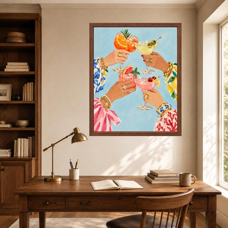 May include: A framed wall art print depicting four hands raised in a toast, each holding a different cocktail glass. The drinks are garnished with orange slices, cherries, and herbs. The hands are adorned with gold bracelets and rings.