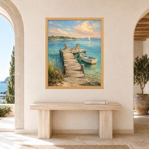 May include: A framed wall art print depicting a wooden pier extending into calm blue water. Two chairs sit at the end of the pier, with a small white boat moored alongside. A distant sailboat is visible under a soft, light-filled sky with clouds.