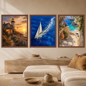 May include: A set of three framed wall art prints. The left print shows a lighthouse at sunset with a white fence. The center print depicts a white sailboat on deep blue water. The right print features a stone staircase leading to a coastal beach.
