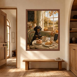 May include: A framed wall art print depicting a black and tan dachshund sitting at a round table in a rustic kitchen. The table holds a donut, a slice of pie, and a mug labelled Warm Cider. A window shows an orchard with autumn trees.