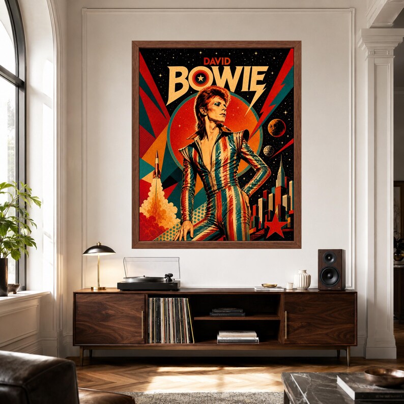 May include: A framed wall art print featuring a stylised illustration of David Bowie in a striped jumpsuit against a cosmic background with a rocket, planets, and a city skyline. The text DAVID BOWIE is printed in bold yellow letters at the top.