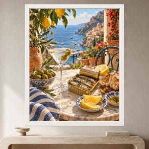 May include: A framed wall art print depicting a Mediterranean scene with a martini glass containing two olives, a tin of sardines, a bowl of green olives, lemon wedges, and bread on a marble table, set against a coastal cliffside view.