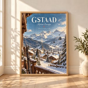 Framed Gstaad Switzerland travel poster showing a snowy Swiss Alps village with wooden chalets, cable cars, ski slopes, mountain peaks and a pair of skis beside a wooden balcony.